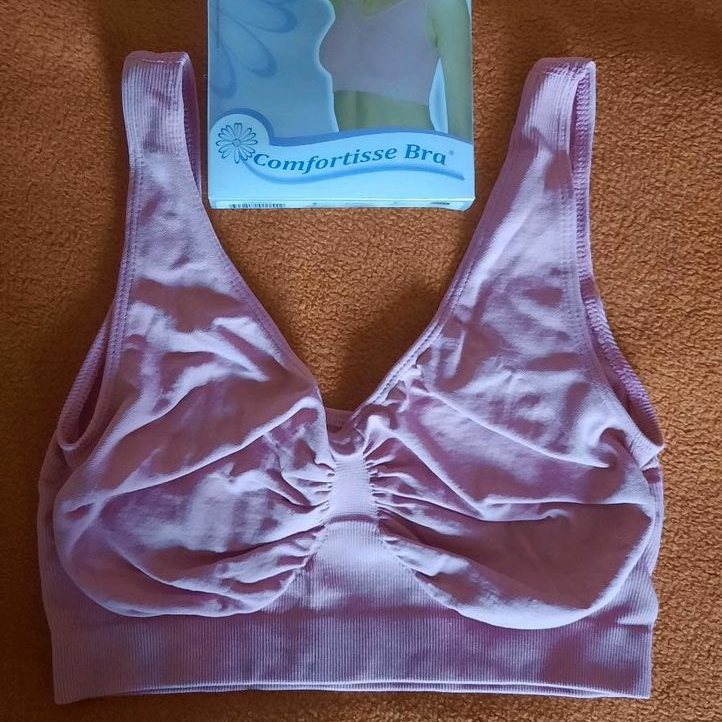 Image of a pink Comfortisse Bra on a bed